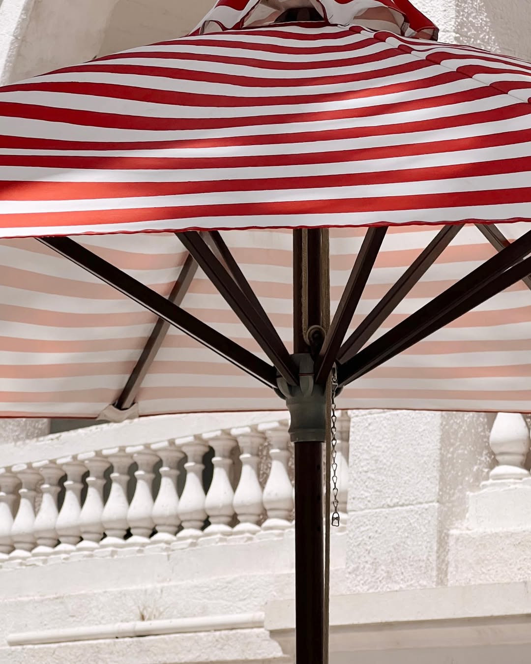 Sombrilla a rayas rojas y rosadas